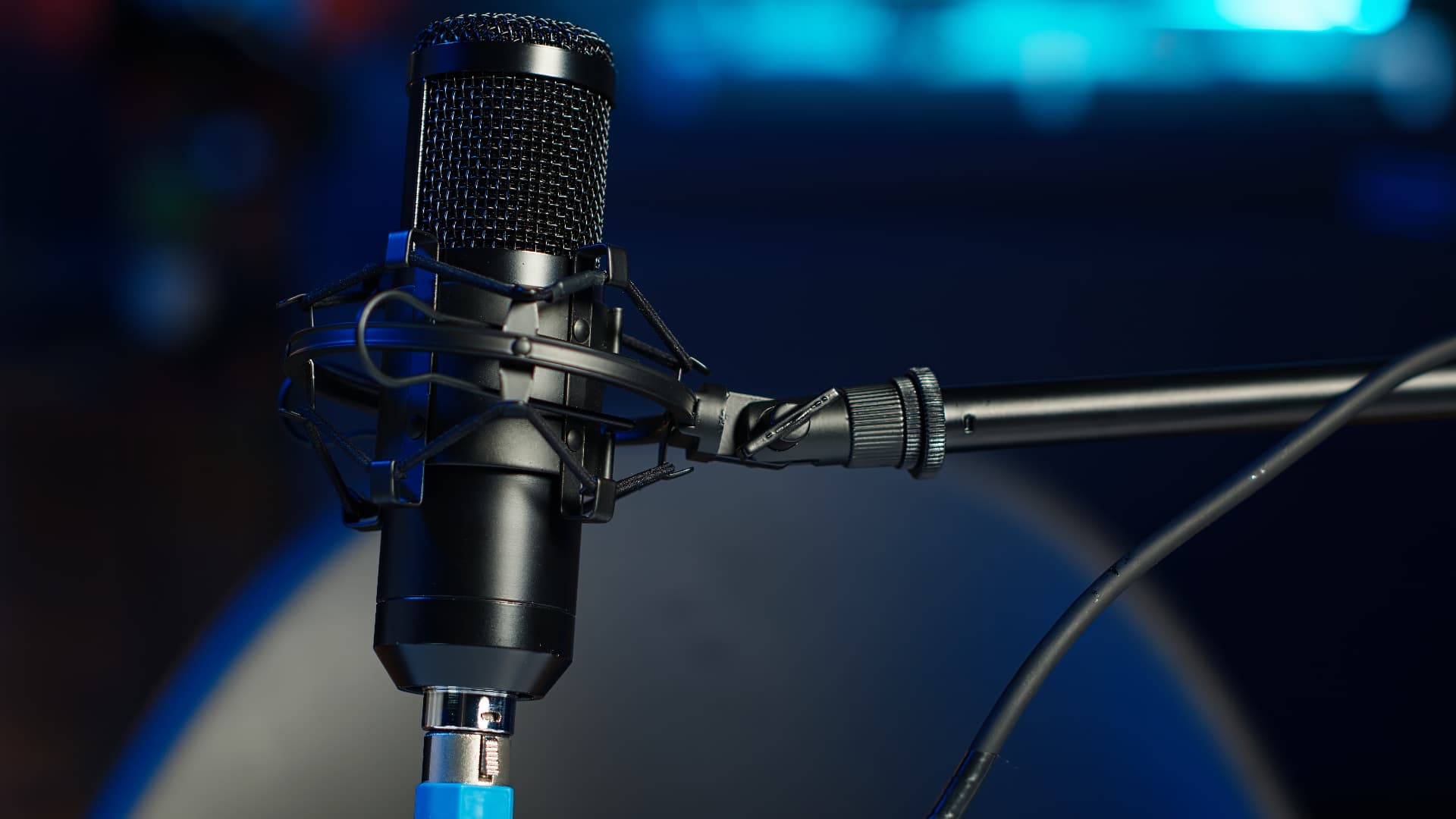 Micrófono de condensador en estudio con iluminación azul profunda